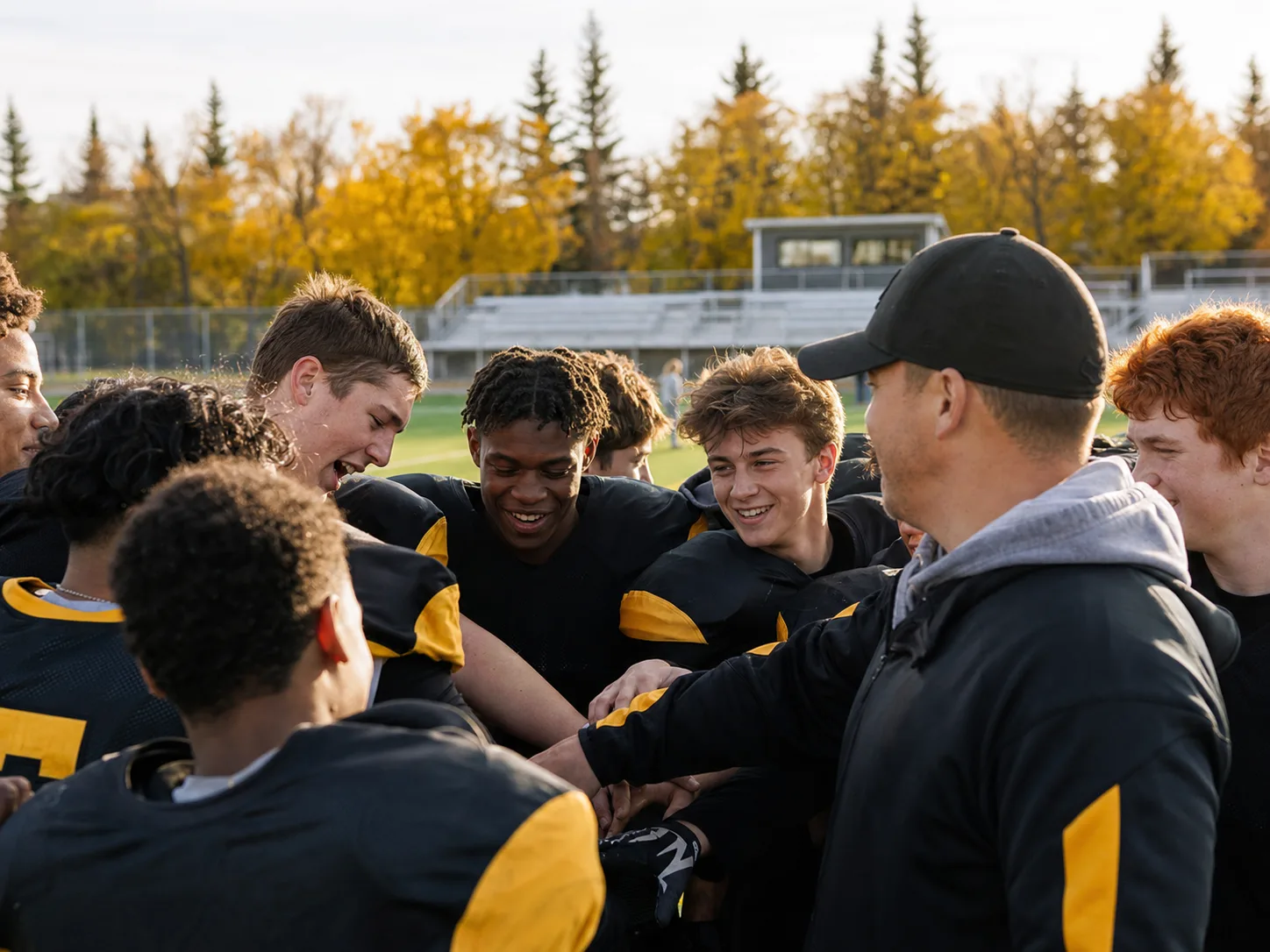 Youth football players gathering with their coach